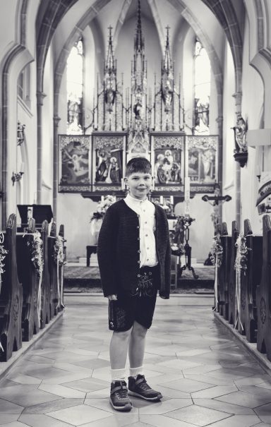 Kind bei Kommunion Fotoshooting im Freien mit natürlichem Licht und emotionalem Ausdruck