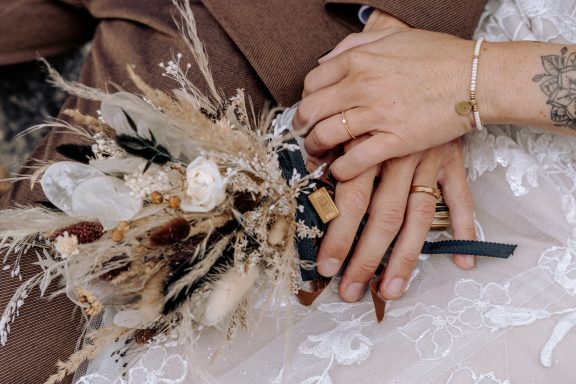 Detailaufnahme von Brautstrauß und Hochzeitskleid, München